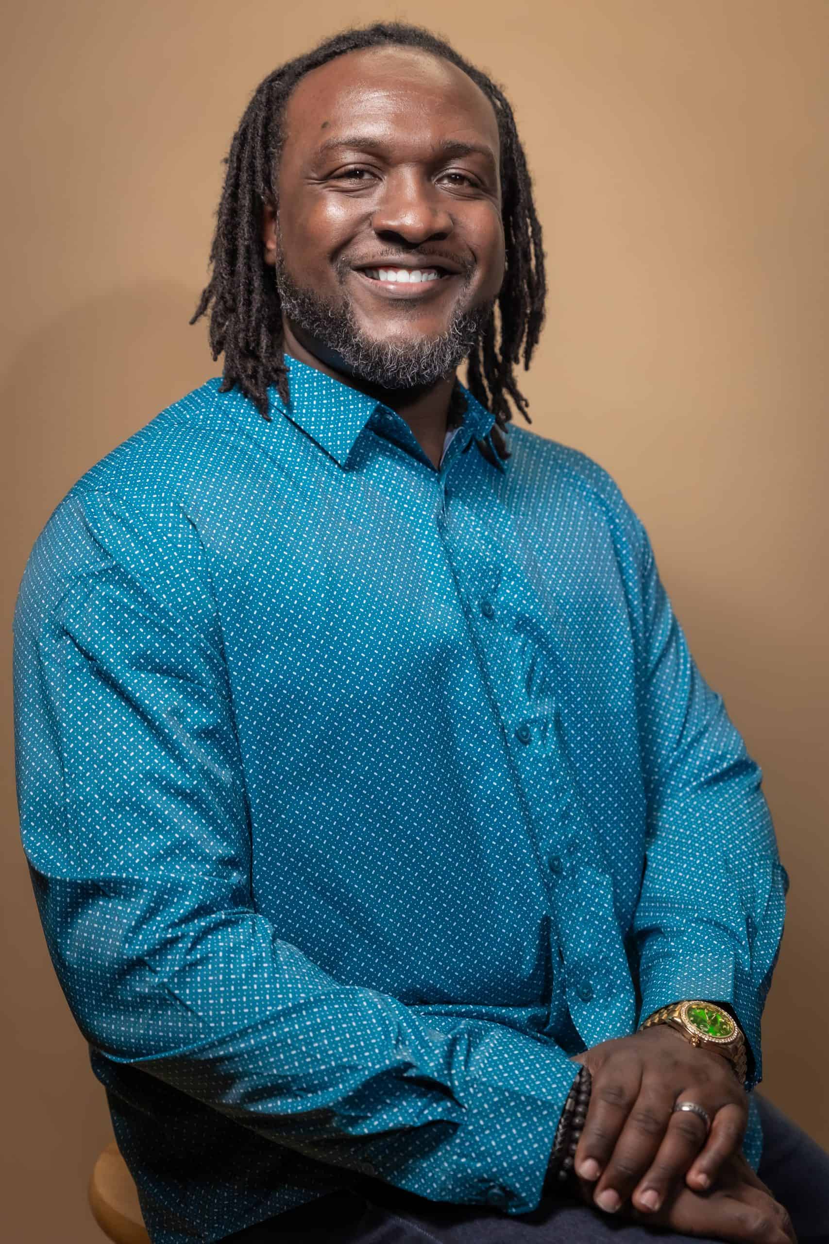 Image of James Sanders Smiling against a brown background