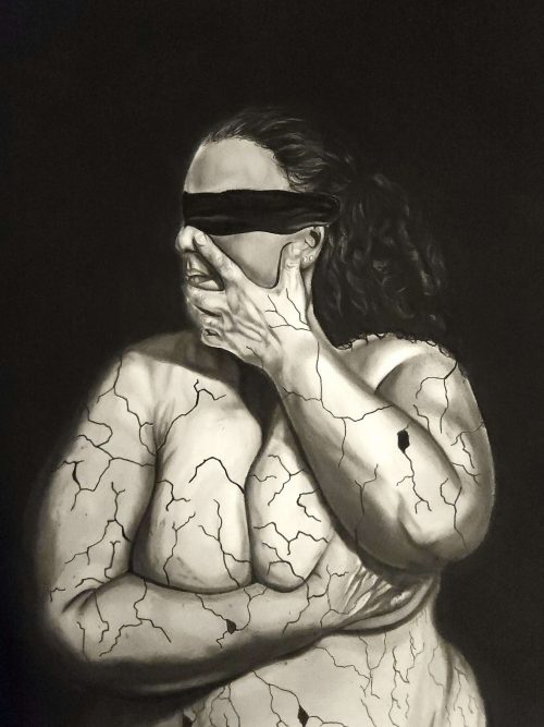 Graphite and charcoal drawing, 'In Pieces pt. 1.' The piece features the torso of a man wearing a blindfold. He crosses his arms to hold himself in a protective gesture, while cracks spiderweb across his skin, rendered with detailed shading to resemble fractured concrete. The monochrome artwork evokes a powerful sense of vulnerability and hidden turmoil.