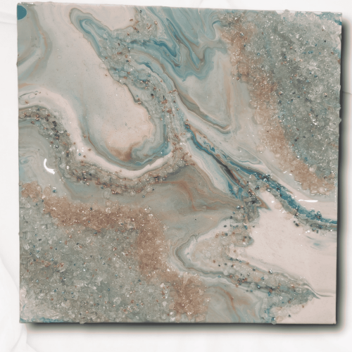 Image of a teal and coral geode art piece by artist James Sanders. It features a combination of the colors teal, coral, white, and rose gold, embellished with resin, fire glass, and gem stones.